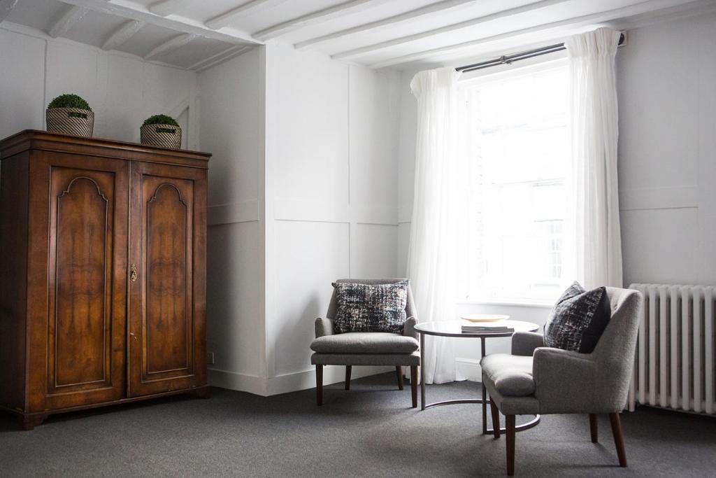 a living room with two chairs and a cabinet at Whitehouse Rye in Rye