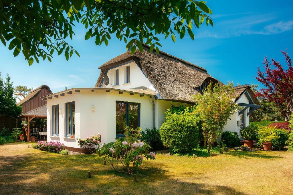 ein altes Haus mit einem Strohdach in der Unterkunft Ferienhaus Ankerherz in Wustrow