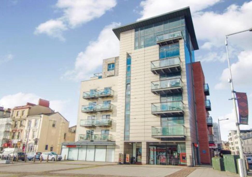 ein hohes Gebäude mit Balkon an der Seite in der Unterkunft Quayside Apartment in Cardiff Bay in Cardiff