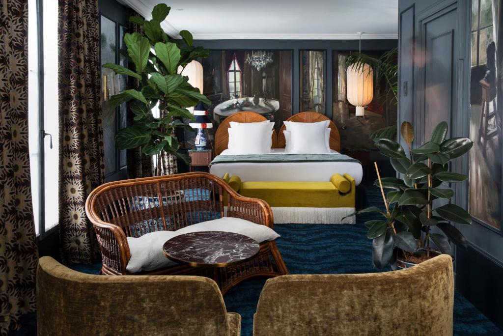 a bedroom with a bed and a table and chairs at Hôtel Monte Cristo in Paris
