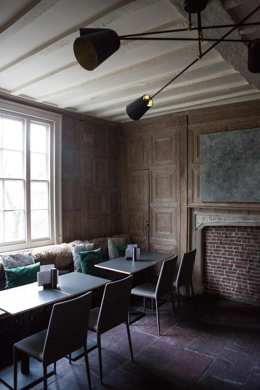 two tables and chairs in a room with a fireplace at Whitehouse Rye in Rye