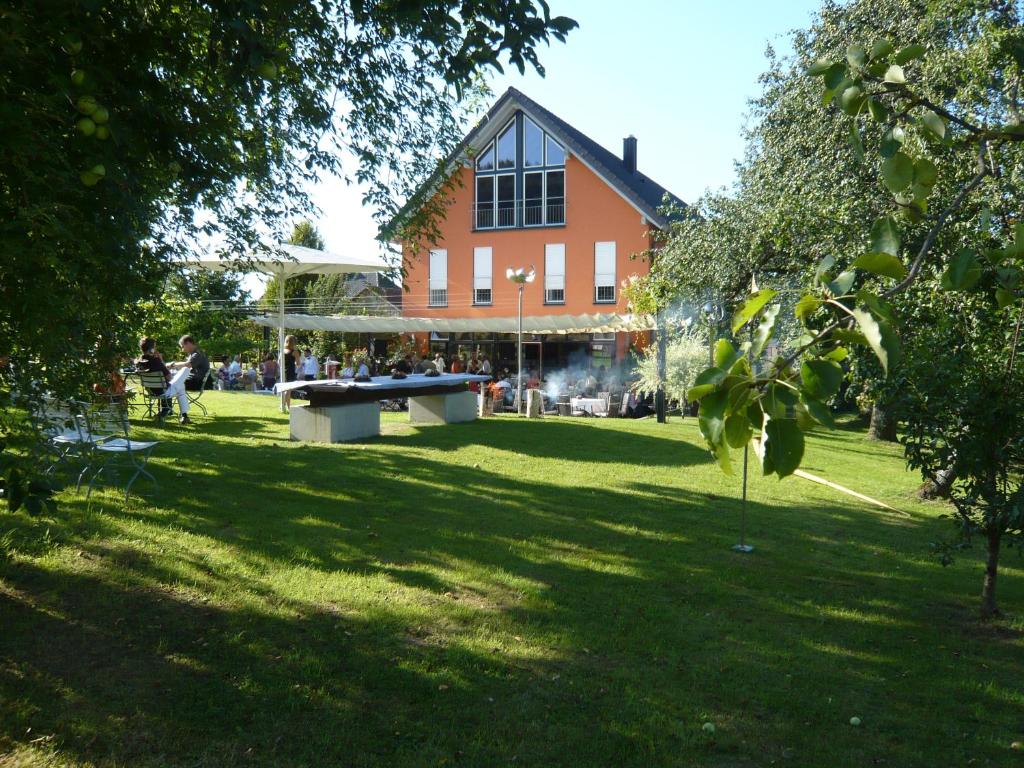 a building with a picnic table in the grass at Hotel Zapa in Singen