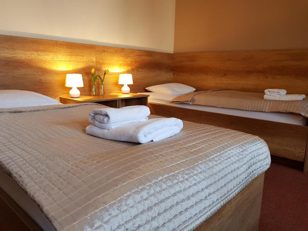 two beds in a hotel room with towels on them at Hotel Vector in Tarnowo Podgórne