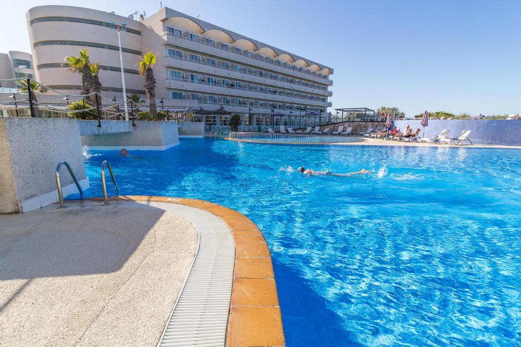 uma piscina em frente a um grande edifício em Eix Platja Daurada Hotel & SPA em Can Picafort