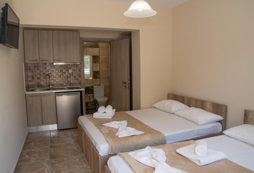 two beds in a small room with a kitchen at Olympic Coast in Olympic Beach