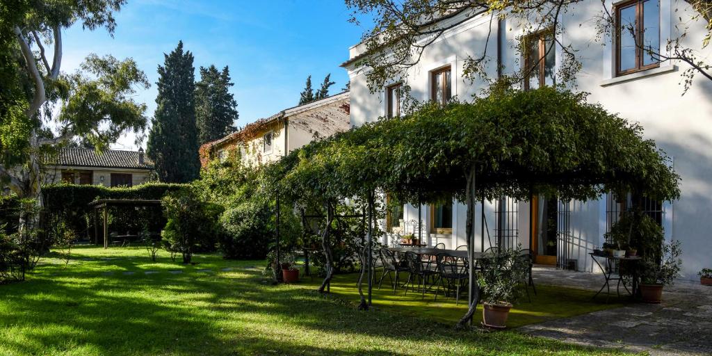 a garden with a table and chairs in front of a house at Masseria GiòSole in Capua