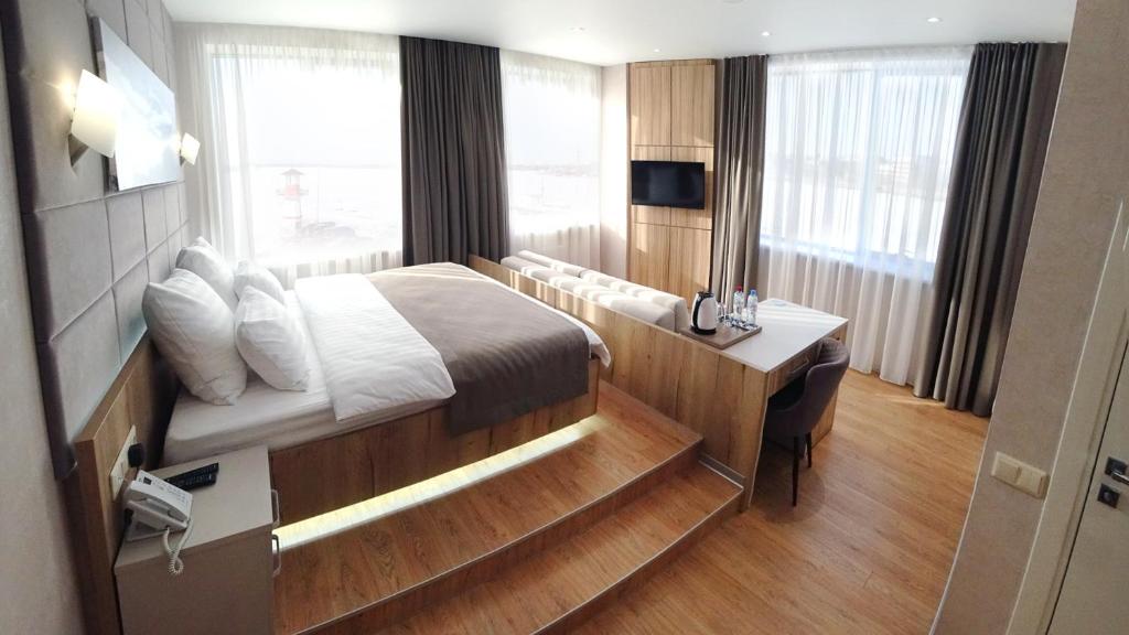 a hotel room with a bed and a desk and window at F911 Яхт Клуб Отель in Yekaterinburg