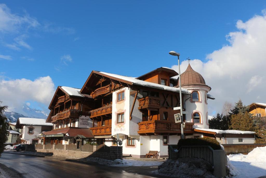 a large building with wooden balconies on a street at Pension Singer in Innsbruck