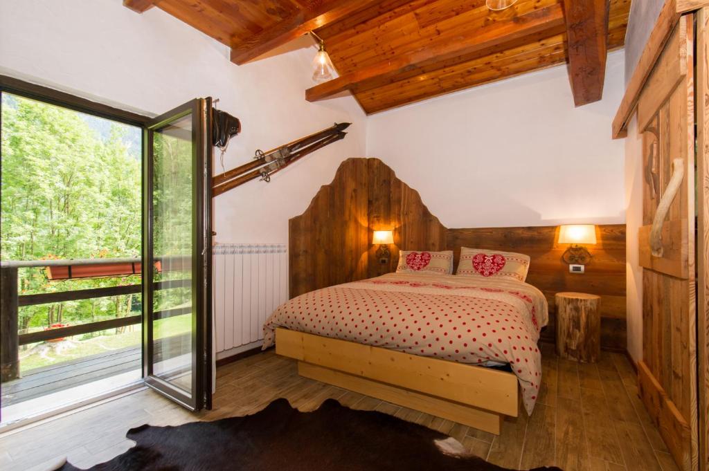 a bedroom with a bed and a large window at B&B La locanda delle pulci Bio Welness in Mezzana