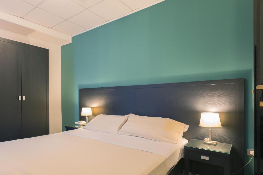 una camera con un grande letto con una parete blu di Executive Business Hotel a Bari