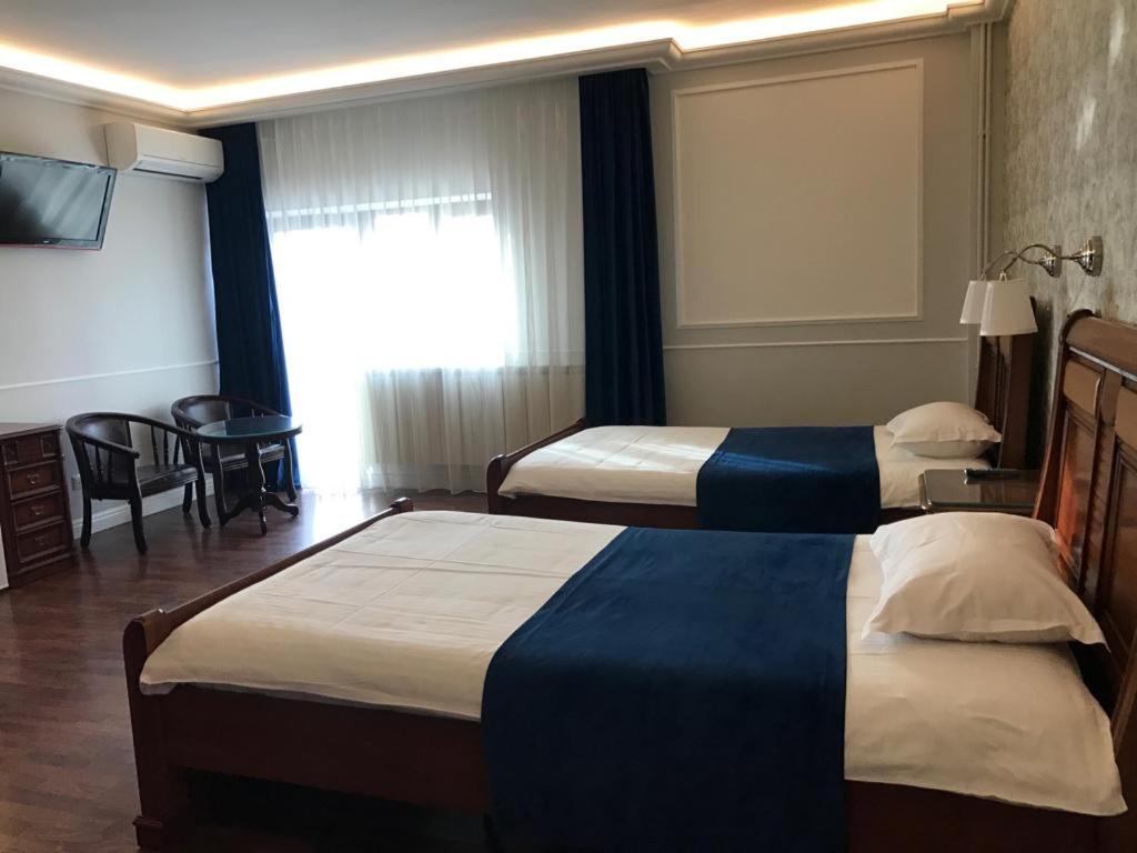 a hotel room with two beds and a television at Pension Hanul Andritei in Craiova