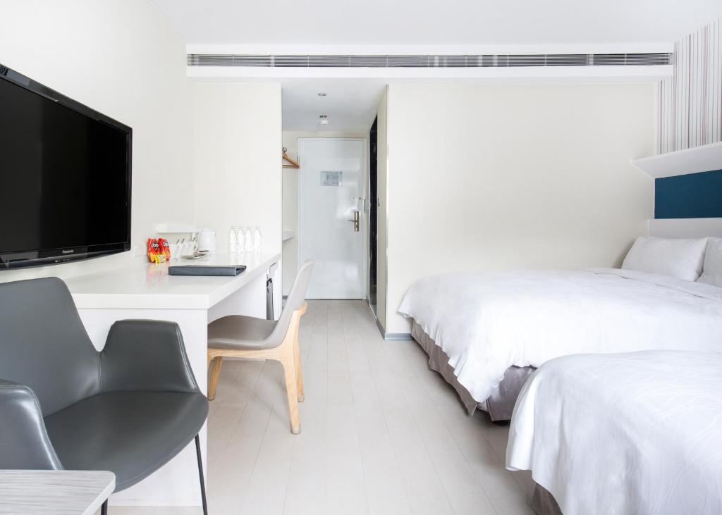 a hotel room with a desk and a bed at Dandy Hotel - Tianmu Branch in Taipei