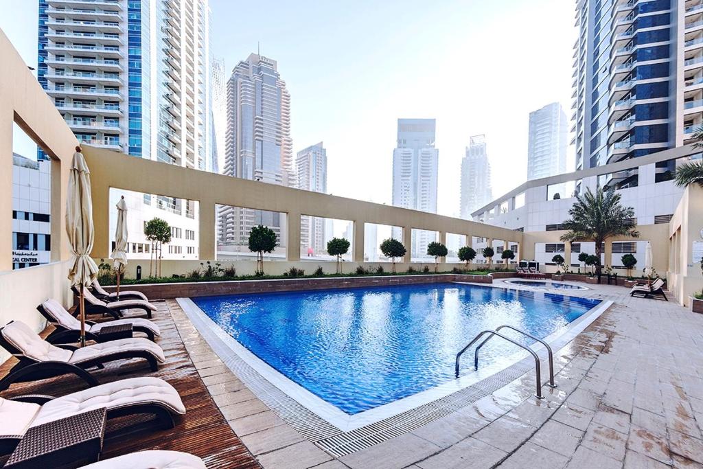 a swimming pool in the middle of a city with tall buildings at Wow! Super Luxury Apartment in Dubai Marina - 1BR RO in Dubai