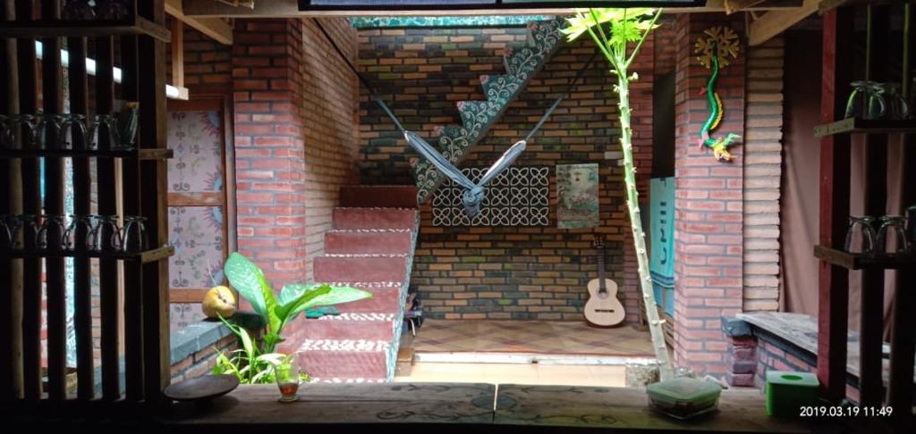 a brick wall with a clock and a guitar at Gado-gado BnB in Yogyakarta
