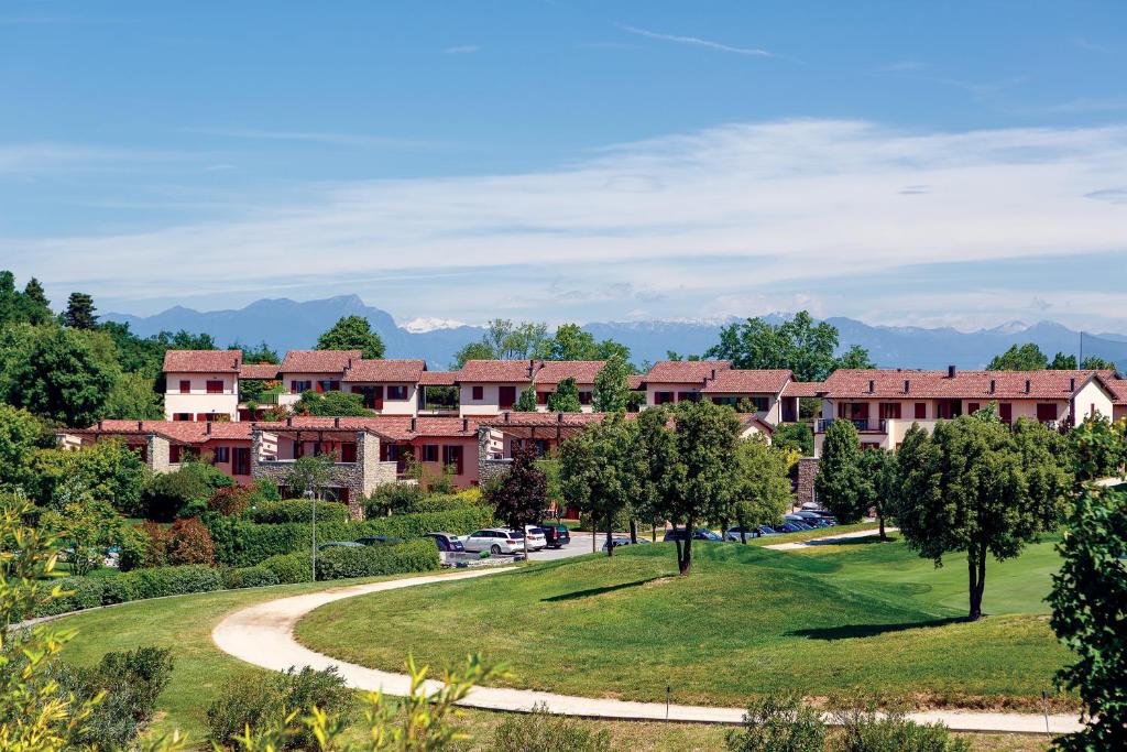 budynek ośrodka z krętą drogą w parku w obiekcie Golf Residenza w mieście Peschiera del Garda