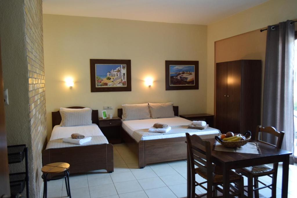 a hotel room with two beds and a table and a dining room at Marika House in Stavros