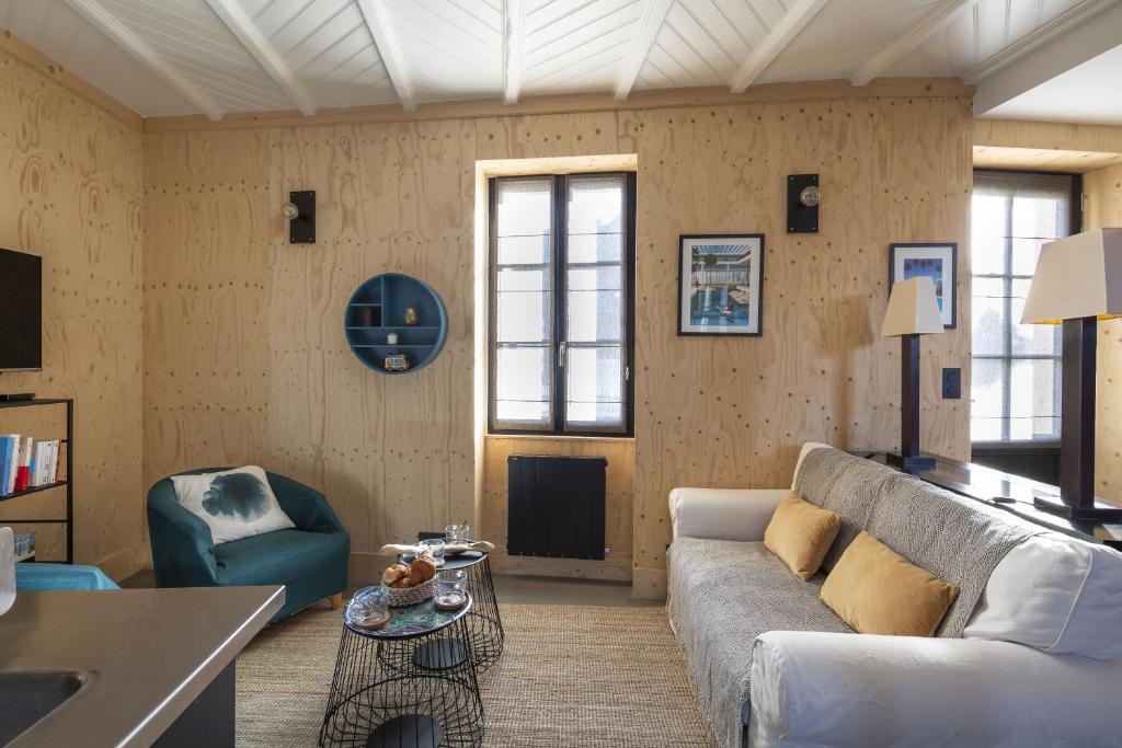 a living room with a couch and a table at La Hune by Cocoonr in Saint Malo