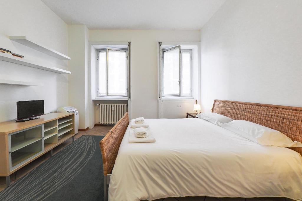 ein Schlafzimmer mit einem großen Bett und einem TV in der Unterkunft PrimoPiano - Ressi in Mailand