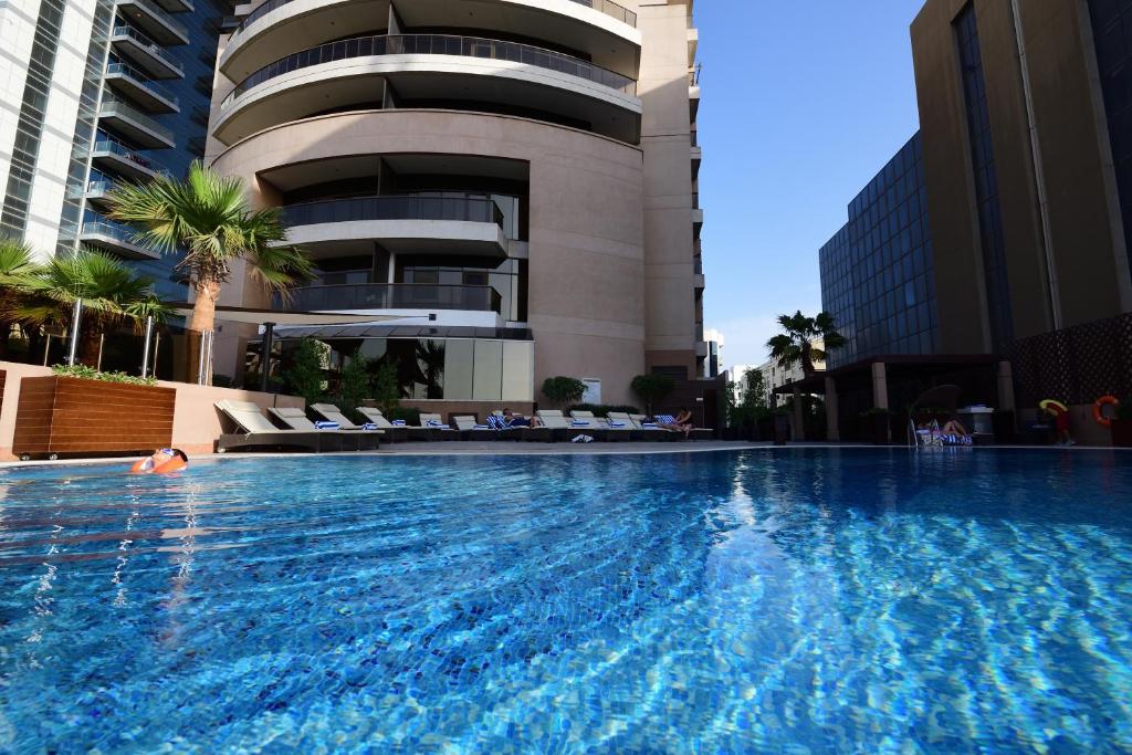 a large swimming pool in front of a building at Majestic City Retreat Hotel in Dubai