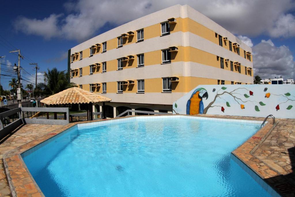 a hotel with a swimming pool in front of a building at Nascimento Praia Hotel in Aracaju