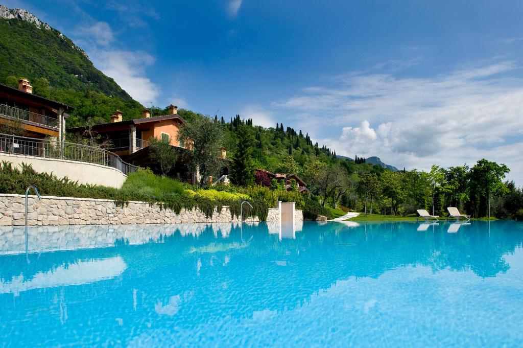 una gran masa de agua azul con casas en el fondo en Apartments Golf Bogliaco, en Toscolano Maderno