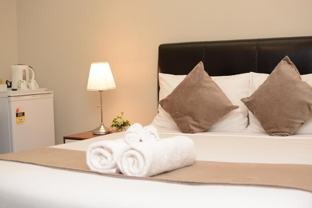 1 dormitorio con 1 cama con toallas en Ellard Bed & Breakfast en Perth