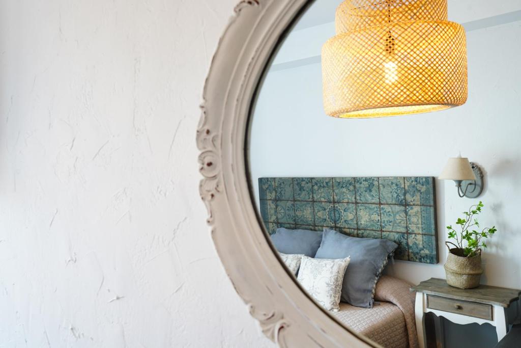 a mirror in a room with a couch and a lamp at Hostal Sa Malica in Blanes