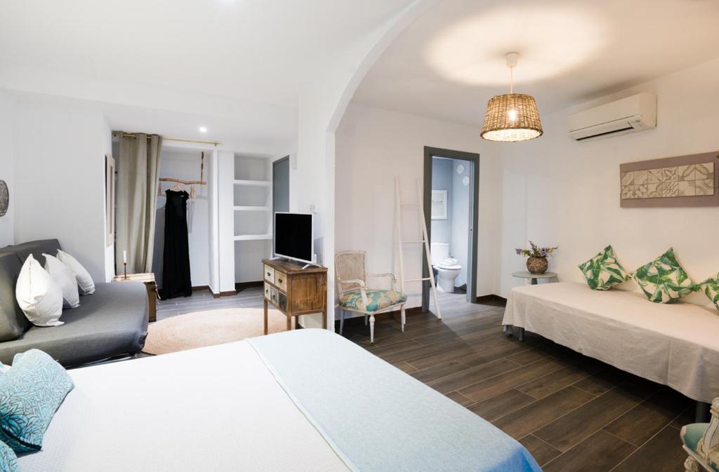 a hotel room with two beds and a living room at Hostal Sa Malica in Blanes