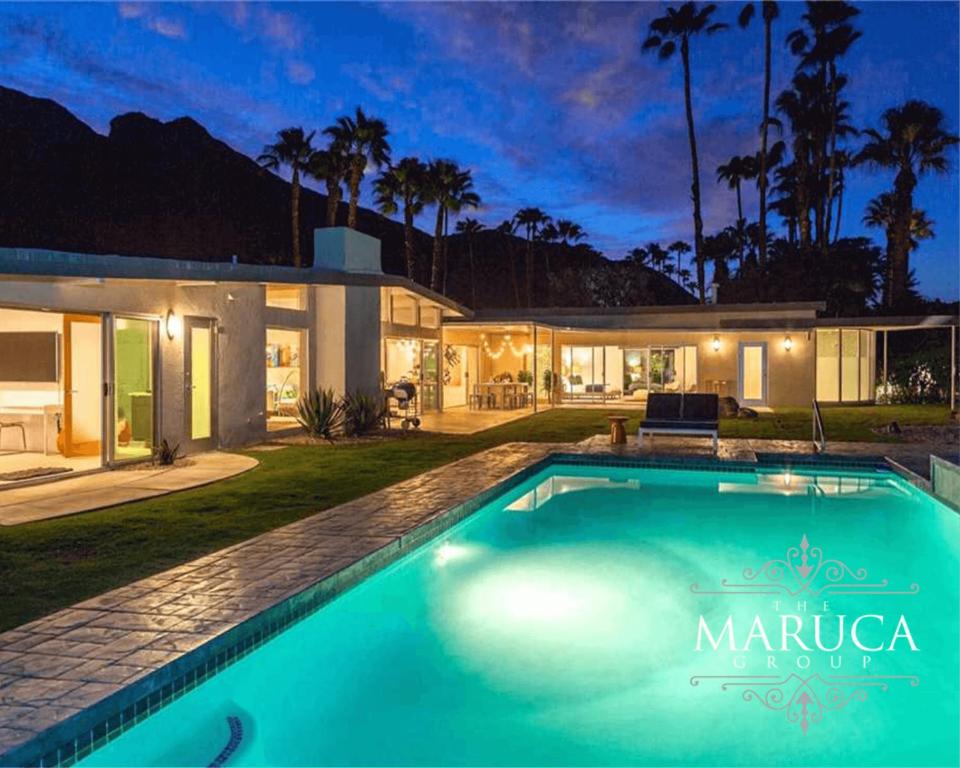a swimming pool in front of a house at Villa Finola in Palm Springs
