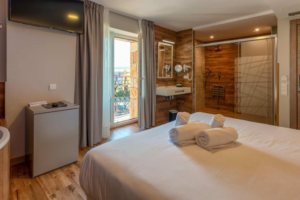 a bedroom with a large white bed with towels on it at Hotel Gastronómico Torre de Galizano in Galizano