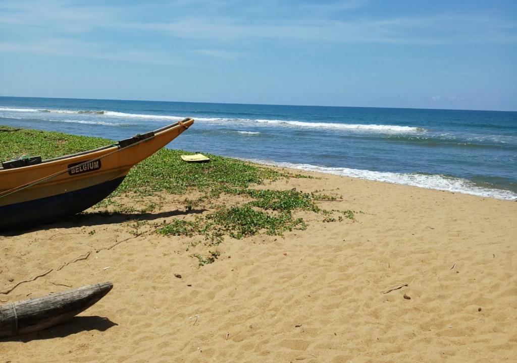a boat sitting on a beach next to the ocean at VILLA CHAND KALUTARA in Kalutara