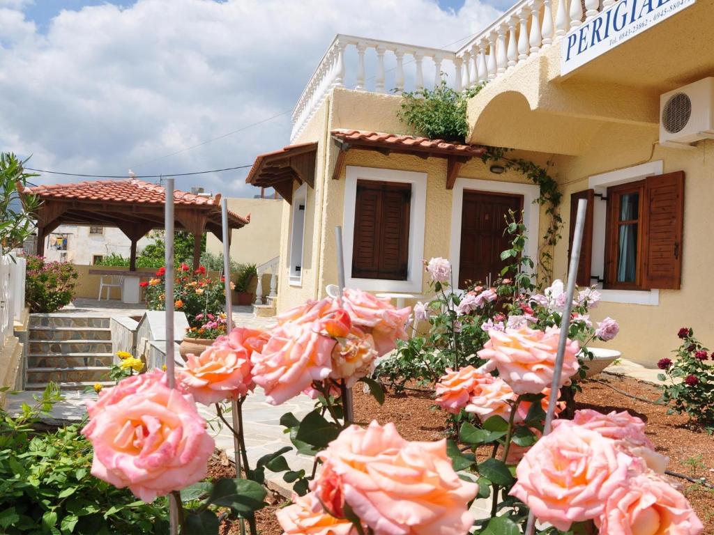 a bunch of pink roses in front of a house at Perigiali in Makry Gialos
