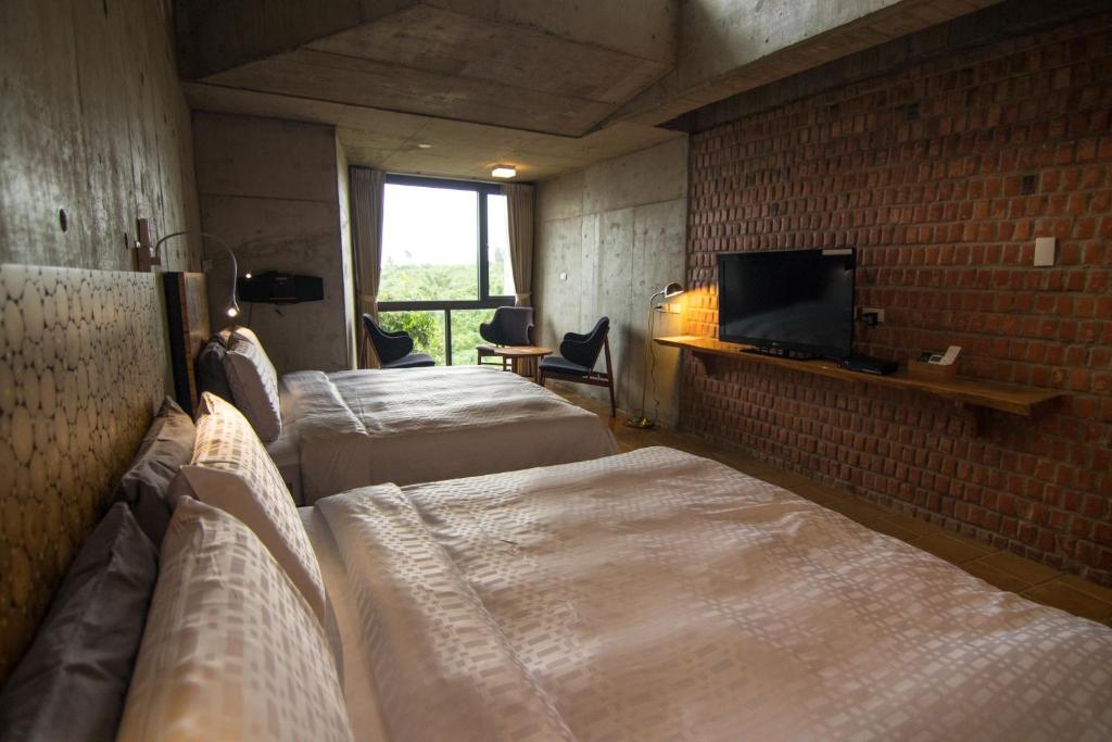 a room with two beds and a tv in a room at The Light in Hengchun South Gate