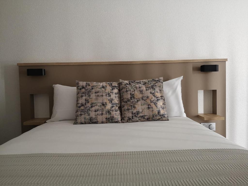 - un grand lit avec 2 oreillers dans l'établissement AMHotel Italie, à Paris