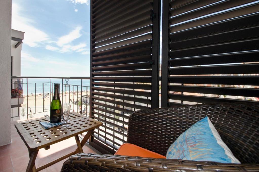 eine Flasche Wein auf dem Tisch auf dem Balkon in der Unterkunft Cal Xillo in Torredembarra