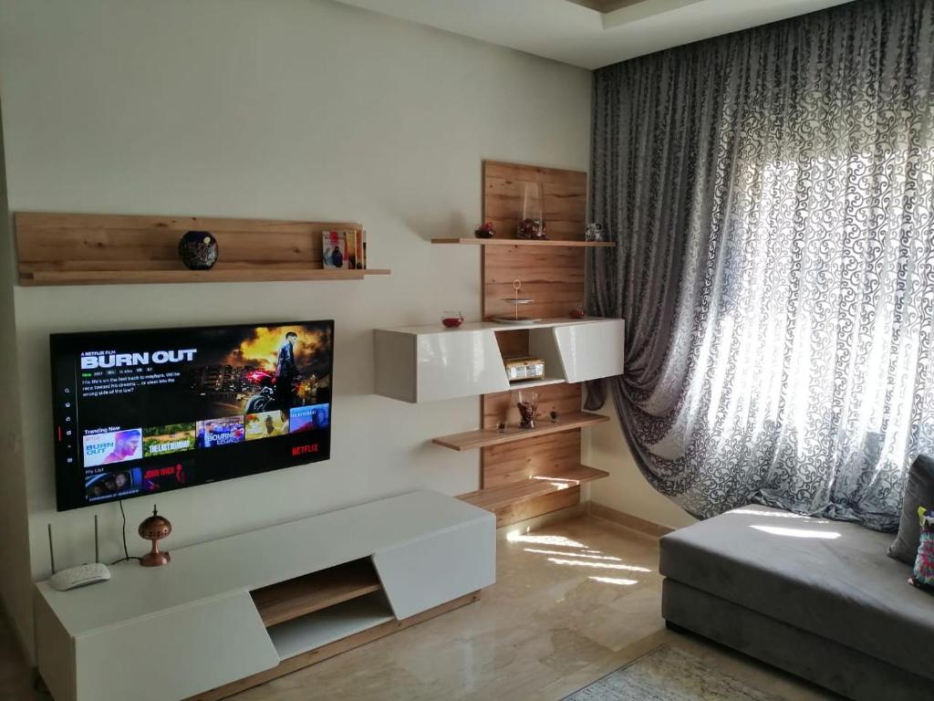 un soggiorno con TV a schermo piatto a parete di Luxury résidence Taj Nouaceur a Nouaseur