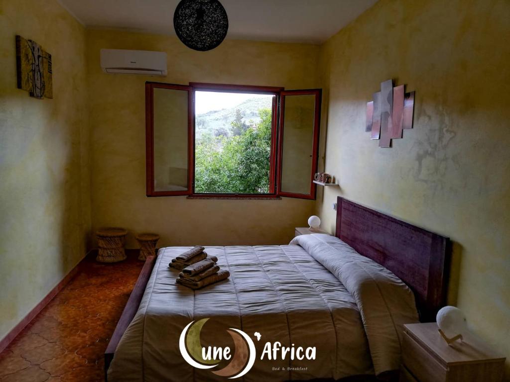 1 dormitorio con 1 cama grande y ventana en Lune d'Africa, en Furtei