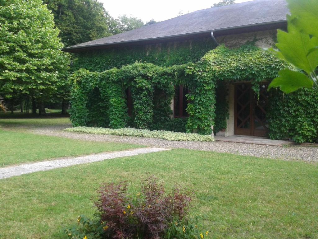 a building covered in green ivy next to a yard at La Passagere in Hauterive