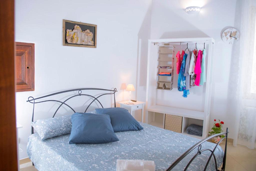 a bedroom with a bed and a rack of clothes at Dimora Porto Canale in Monopoli