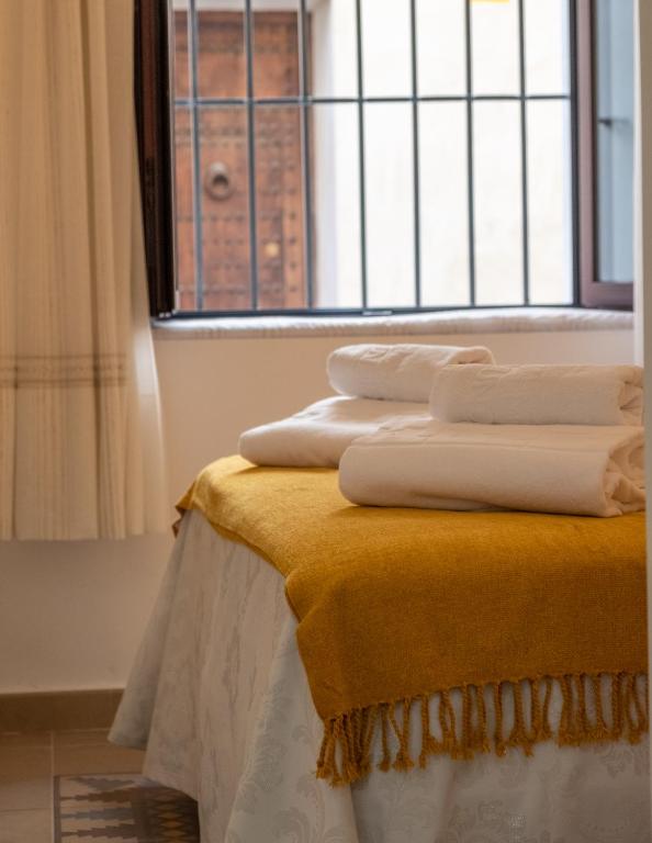 A bed or beds in a room at La Judería del Buen Viaje
