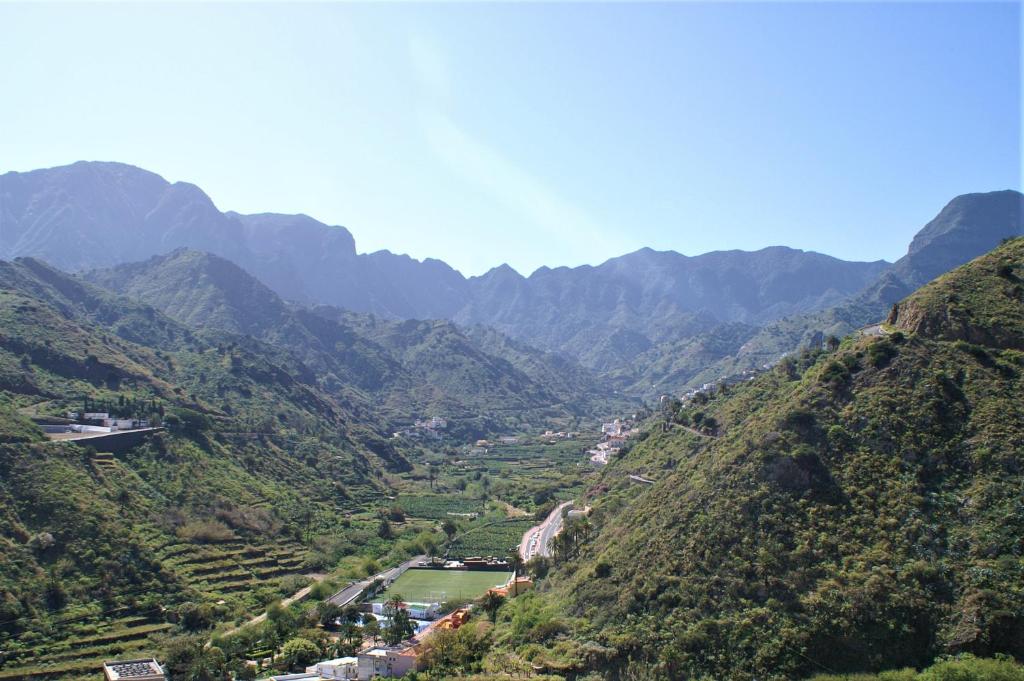 Elle offre une vue sur une vallée avec une rivière et des montagnes. dans l'établissement Apartamento Maruca, à Hermigua