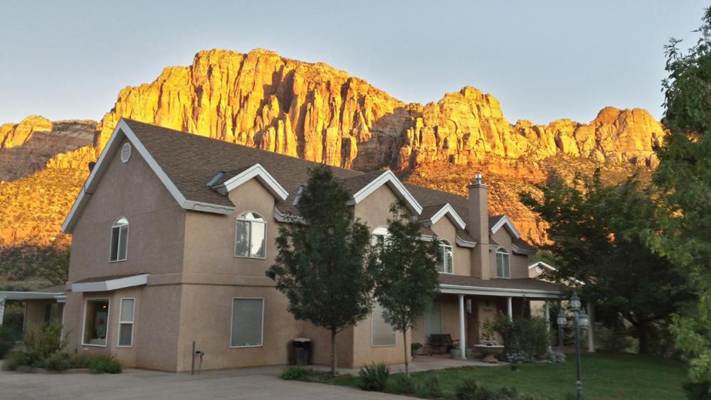 a house with a mountain in the background at Novel House Inn at Zion in Springdale