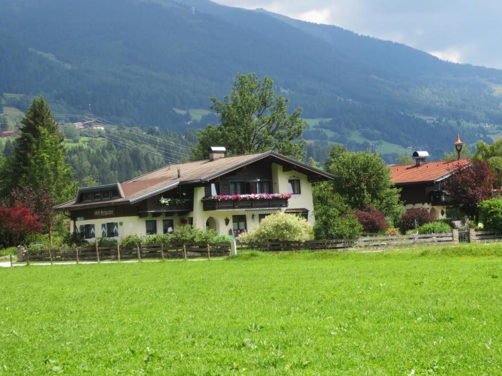 una casa en un campo con un campo verde en Gästehaus Scharler en Neukirchen am Großvenediger