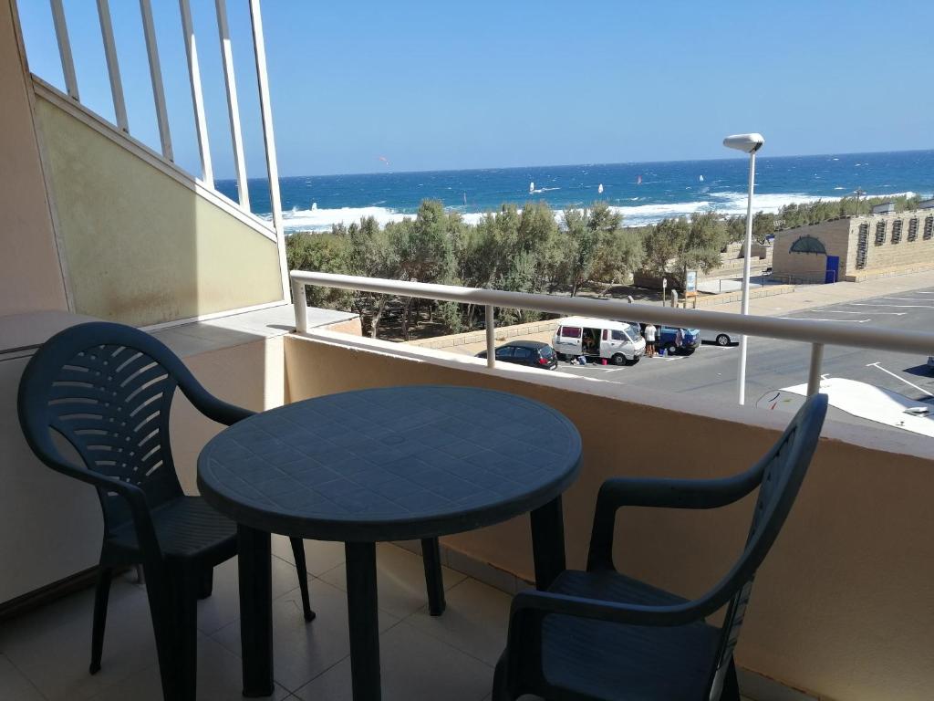 a table and chairs on a balcony with a view of the ocean at Oceanside Apartment in El Medano in El Médano