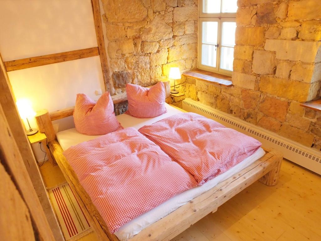 Bielatalにある"Gesindestube" - Hammergut Neidbergのベッドルーム1室(ピンクのシーツと枕のベッド1台付)