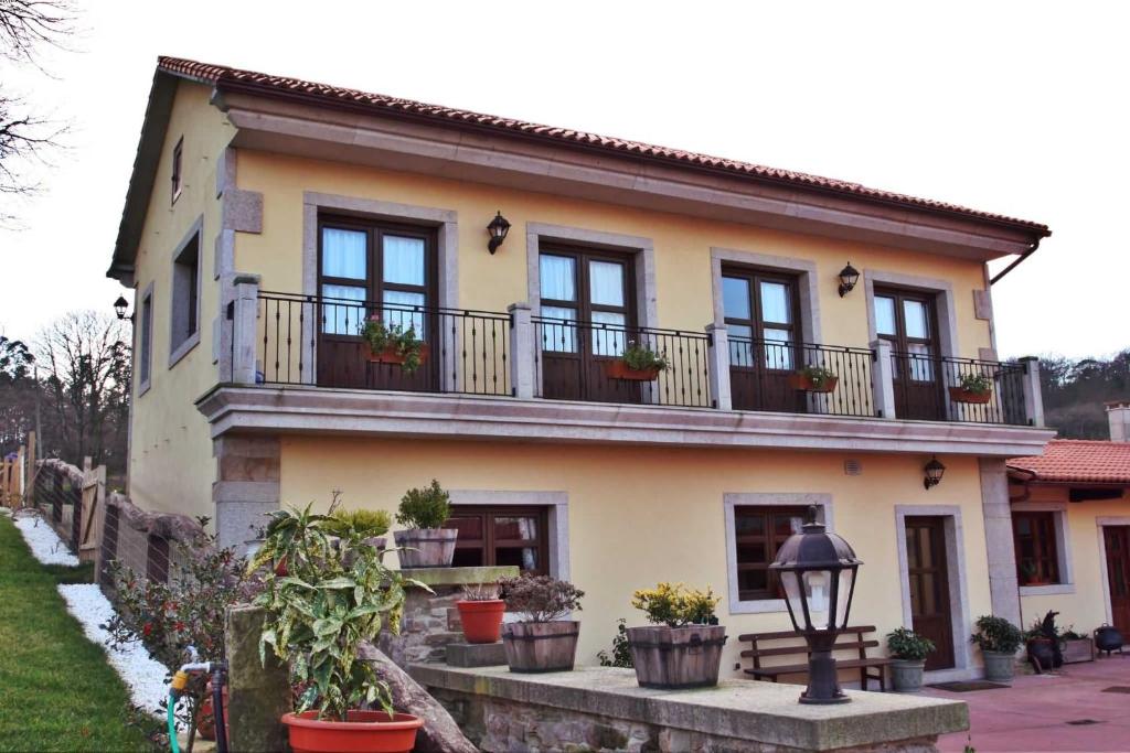 a house with potted plants on the balcony at Palleira de Roque in Bermés