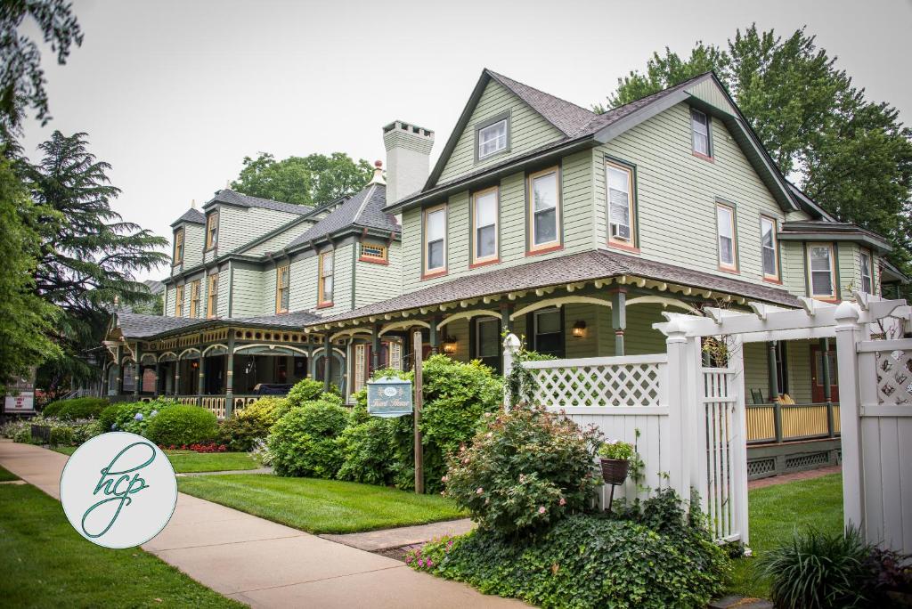 a house with a white fence in front of it at Vandiver Inn in Havre de Grace