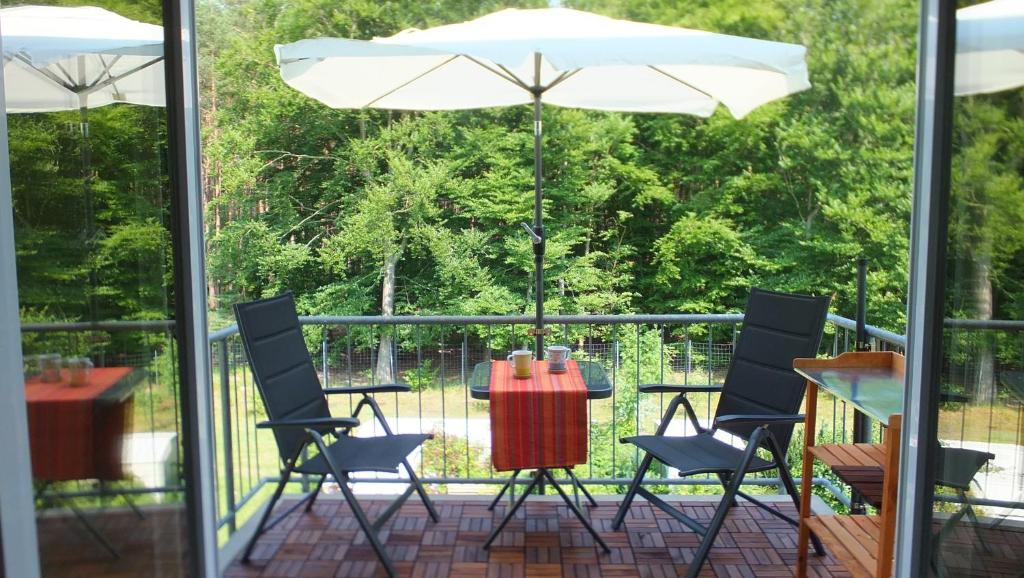 a patio with a table and chairs and an umbrella at Ferienwohnung Schonzeit II in Graal-Müritz