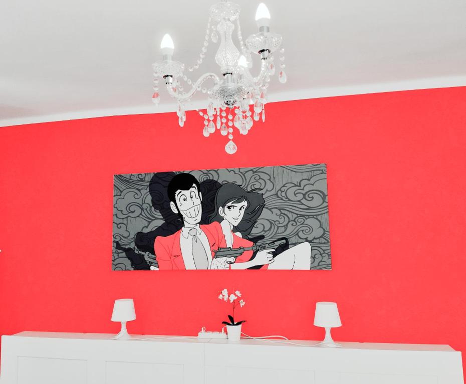 Un dipinto di un uomo e di una donna su un muro rosso di B&B Lupin Trento a Trento