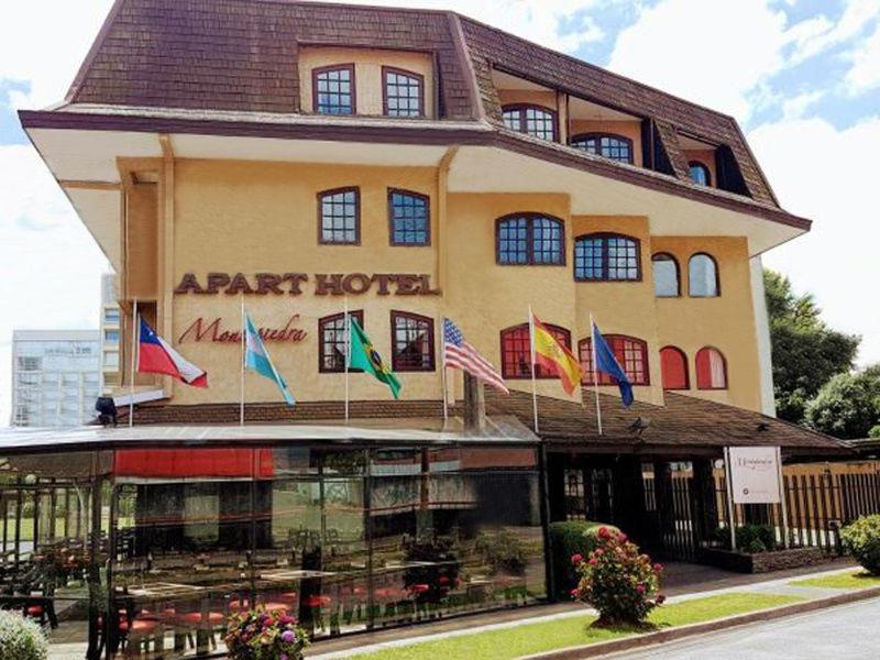 a hotel with flags on the front of it at Apart Hotel Montepiedra in Temuco